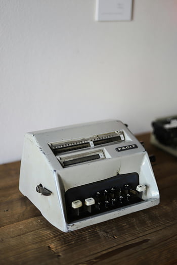 vintage calculator, Facit calculator, retro technology, wooden table, mid-century design, mechanical calculator, numeric keypad, old-fashioned machine, historical computing device