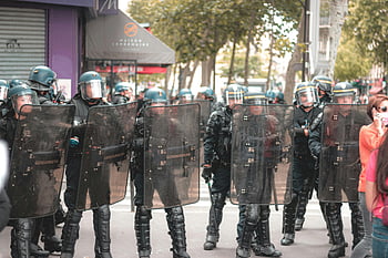 police officers, riot gear, city protest, city street, unrecognizable policemen, standing in line, urban scene, law enforcement, public demonstration, crowd control, protective equipment
