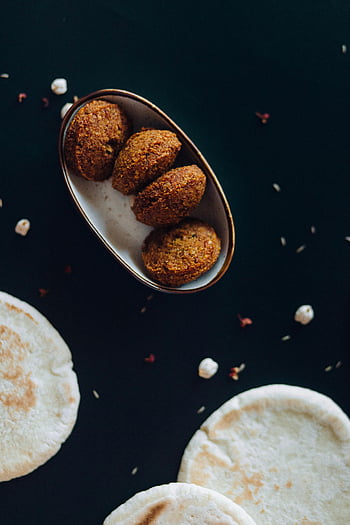 falafel, pide ekmek, gevrek falafel, taze pide, beyaz seramik tabak, kahverengi ve beyaz yemek, yakın çekim, koyu arka plan, orta doğu mutfağı, vejeteryan yemeği, sağlıklı atıştırmalık