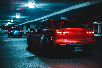 Red Mitsubishi Lancer Evo, parking garage, dimly lit, night, car, vehicle, rear view, tail lights, license plate, urban, garage lights