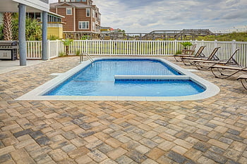 pool near fence, relaxing poolside patio, sun loungers, summer retreat, villas, outdoor pool, patio area, fenced pool, poolside relaxation, pool deck, villa retreat