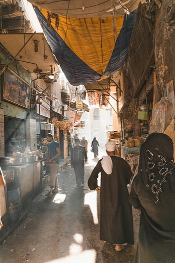 Old Cairo, vibrant street scene, bustling market, colorful tarpaulins, locals walking, street market, traditional clothing, urban market, Egyptian market, street life, cultural scene