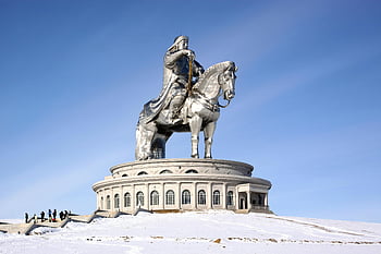 Genghis Khan statue, horseback statue, winter scene, clear blue sky, Mongolia, iconic monument, snow-covered landscape, equestrian statue, historical landmark, outdoor sculpture, winter tourism
