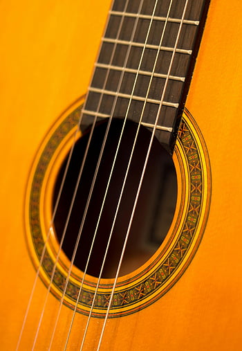 brown wooden guitar, classic acoustic guitar, intricate design, detailed view, guitar strings, guitar sound hole, wooden instrument, musical instrument, acoustic guitar details, guitar craftsmanship, guitar close-up