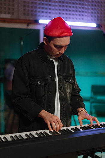Pria bermain keyboard, beanie merah, Studio musik, jaket hitam, pemain keyboard, Pengaturan Studio, pemusik, tuts piano, produksi musik, Studio rekaman, keyboard elektronik