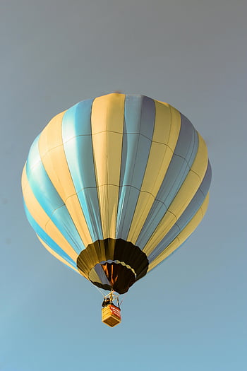 blue and yellow hot air balloon, vibrant hot air balloon, clear summer sky, adventure themes, travel themes, soaring hot air balloon, blue sky, hot air balloon ride, aerial view, outdoor activities, summer adventure