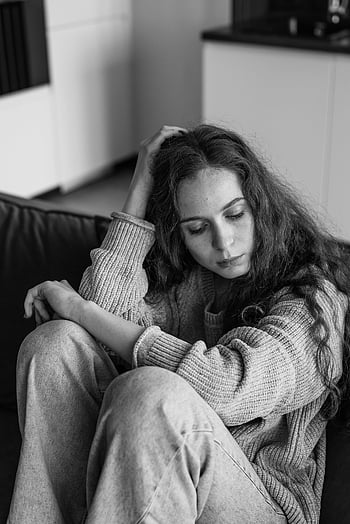 kvinna i tröja, sitter på soffan, svartvitt, inomhusmiljö, tankeväckande kvinna, ensam, soffa, Tröja, svartvitt foto, inomhus-, omtänksam