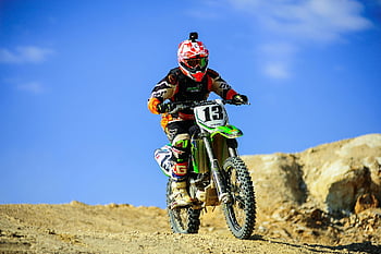 motocross, bicicletta sporca, ciclista, casco rosso, terreno sabbioso, chiaro cielo blu, fuori strada, motociclo, sport all'aperto, azione, avventura