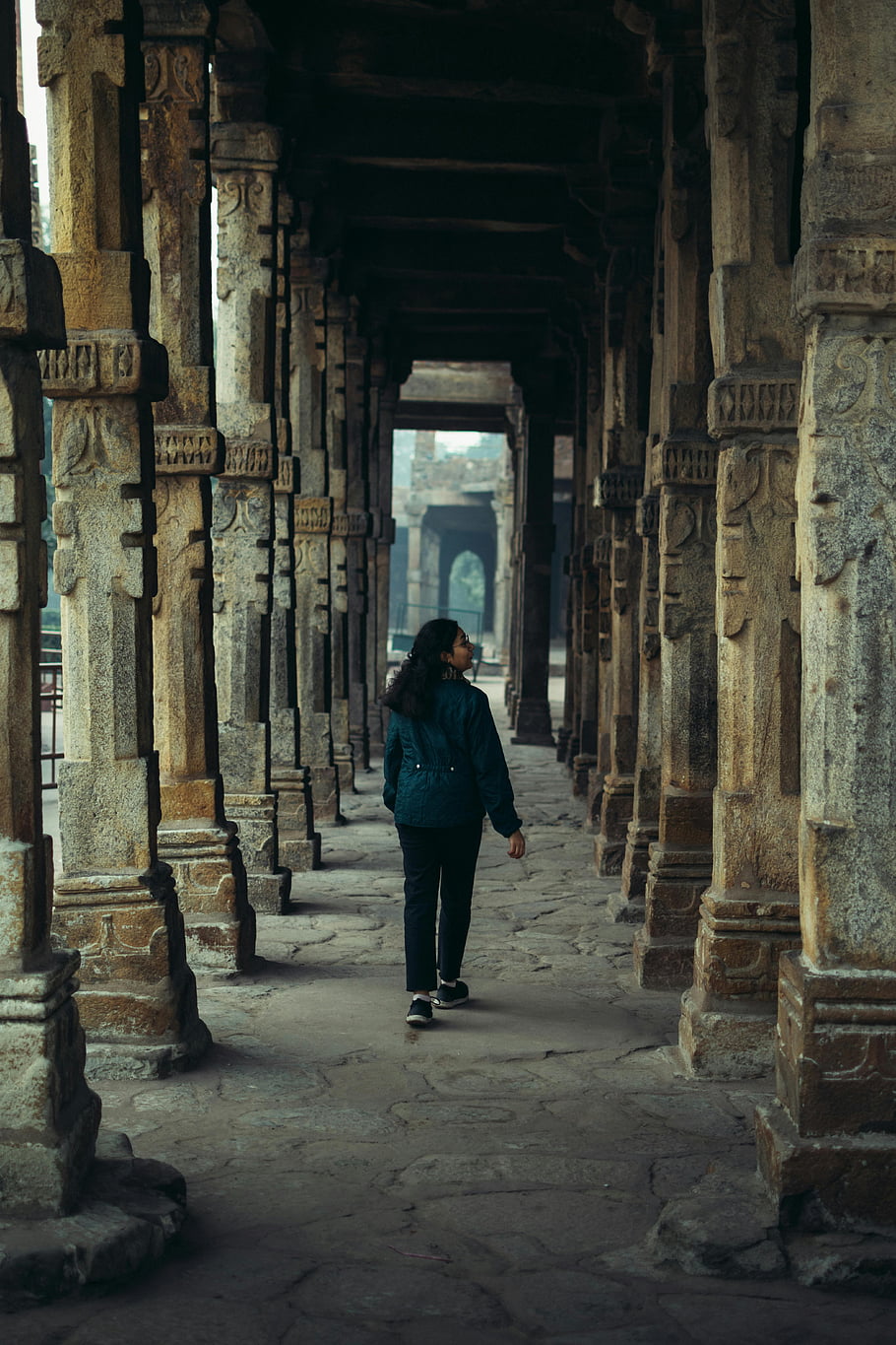 Qutb Minar, Delhi, India, woman sightseeing, ancient stone corridor, intricate architecture, historical monument, travel photography, tourist attraction, cultural heritage, architectural marvel