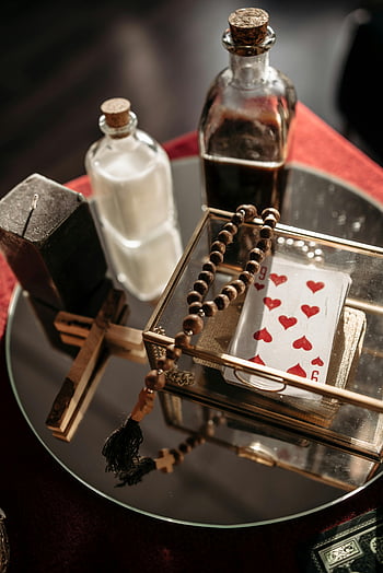 fortune telling, mystical table, cards, beads, bottles, mirror, close-up shot, fortune objects, mystical objects, divination tools, tarot cards