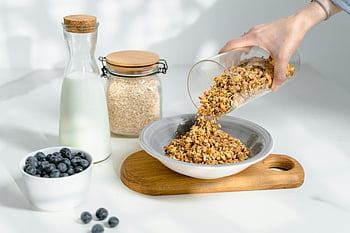 granola, miska, nalévání, mléko, borůvky, výživná snídaně, zdravé jídlo, oves, skleněné nádoby, dřevěné prkénko, Příprava na snídaně