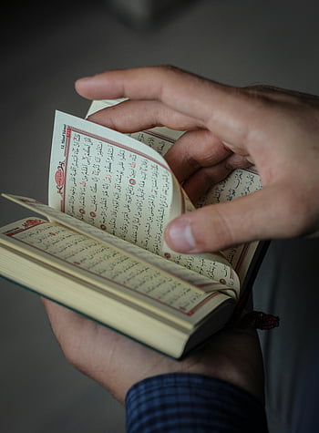 handen die pagina's omslaan, quran, lezing, reflectie, binnenshuis, detailopname, persoon met boek, religieuze tekst, geestelijk, religieuze praktijk, spiritueel lezen