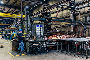 factory machinery, manufacturing factory, worker safety gear, industrial equipment, busy factory, machinery operation, factory worker, safety equipment, industrial manufacturing, factory interior, machinery sparks