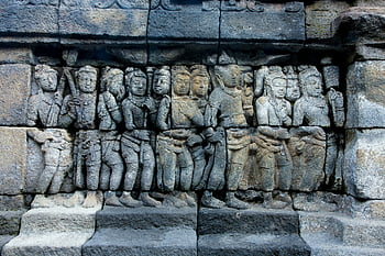 ancient sculpture, stone wall, detailed stone relief, ancient figures, Borobudur Temple, Indonesia, historical art, cultural heritage, stone carving, temple architecture, ancient civilization