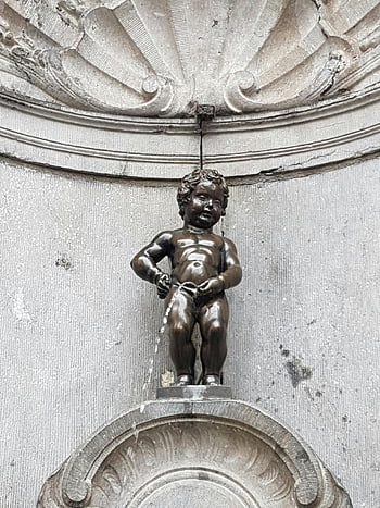 Manneken Pis, Brussels, Belgium, bronze statue, local humor, famous landmark, tourist attraction, European art, historic monument, public fountain, cultural symbol