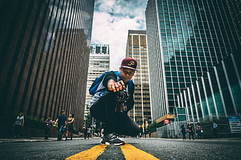 city street, young man, camera, kneeling, bustling, skyscrapers, urban photography, street photography, cityscape, portrait, photographer