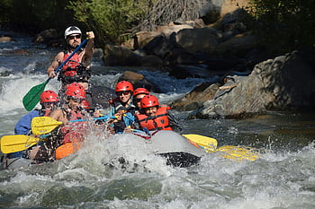 whitewater rafting, inflatable raft, rapid river, group adventure, outdoor activity, safety helmets, paddles, thrilling experience, river rapids, water sport, adventure tourism