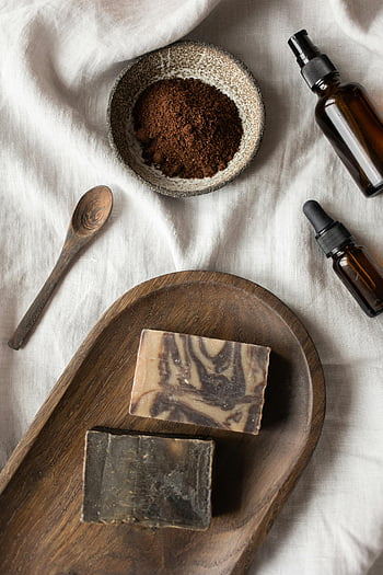 handgjorda tvål, naturliga hudvårdsprodukter, eteriska oljor, lera, lugnande spa -upplevelse, platt låg, kaffe grunder, träslev, träbricka, gula flaskor, spaföremål