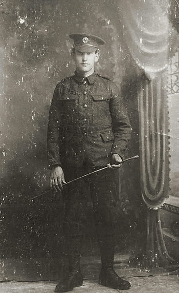 old photo, man, military uniform, classic portrait, young soldier, black-and-white, holding cane, vintage image, historical photograph, uniformed soldier, antique photo