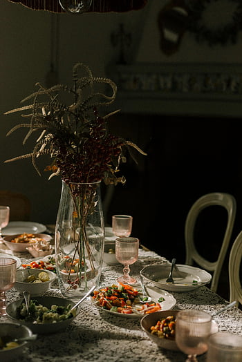 elegant dinner table, floral centerpiece, intimate dinner setting, assorted dishes, dining table, table setting, floral arrangement, dinnerware, table decor, cozy dining, table centerpiece