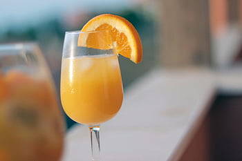 orange juice, clear drinking glass, chilled orange juice, ice in glass, fresh orange slice, summer drink, refreshing beverage, orange garnish, cold orange juice, glass of juice, summer refreshment