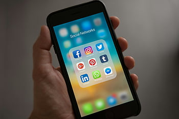 هاتف ذكي،  أيقونات وسائل التواصل الاجتماعي،  يد تمسك الهاتف،  تطبيقات الاتصال الحديثة،  مجلد الشبكات الاجتماعية،  ايفون،  تطبيقات الاتصال،  تطبيقات وسائل التواصل الاجتماعي،  عرض الهاتف الذكي،  يدوية تحمل iPhone