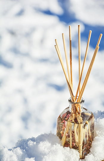 air freshener, fragrant glass diffuser, aromatic scent, reed diffuser, winter scene, snow background, close-up photo, outdoor fragrance, glass bottle, sticks in snow, diffuser sticks