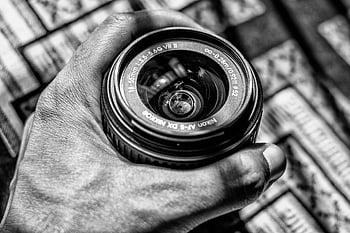 fotografie ve stupních šedi, osoba drží, Objektiv DSLR Zoom, objektiv fotoaparátu nikon, černobílý obraz, Klasické fotografické vybavení, ruka držící čočky, fotografické vybavení, objektiv nikon, černobílé fotografie, kamerové čočky