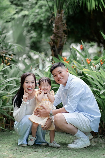 family photo, little girl, tropical garden, smiling family, joy, togetherness, outdoor portrait, family bonding, nature background, happy family, child photography