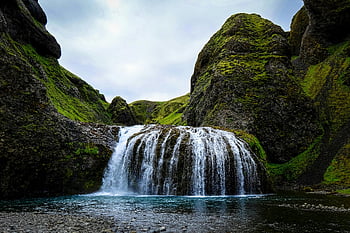 waterfall, moss-covered rocks, mountain landscape, serene beauty, cascading water, natural scenery, outdoor photography, landscape photo, falls, nature's beauty, tranquil setting
