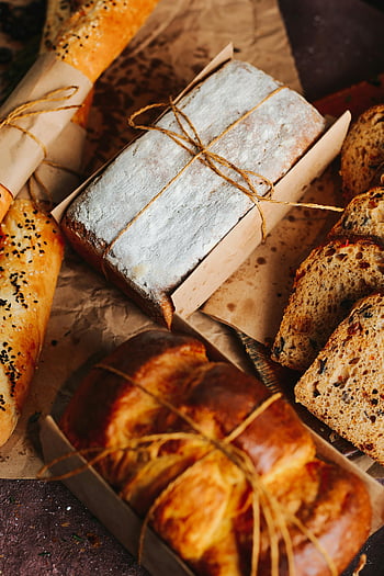 bakery products, bread loaves, wrapped in paper, tied with string, artisanal bread, rustic touch, fresh bread, bakery items, bread packaging, string-wrapped bread, artisanal bakery