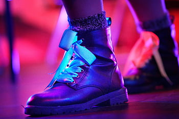 black boots, leather boots, colorful lighting, artistic setting, close-up boots, stylish boots, artistic boots, leather footwear, colorful footwear, artistic footwear, close-up footwear