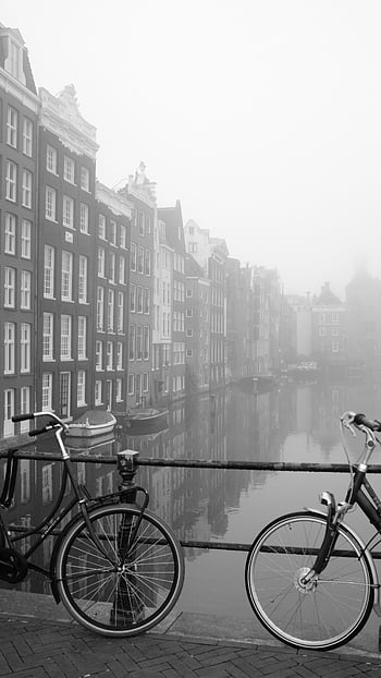 grayscale photo, bicycles, parked, canal bridge, foggy Amsterdam, black and white, body of water, canal, urban scene, cityscape, reflection