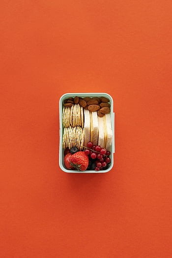 platt låg, näringsrik lunchlåda, crackers, mandlar, frukt, orange bakgrund, Hälsosamma snacks, lunchbehållare, snackbox, matfotografi, livfulla färger