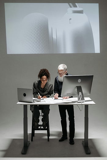 働いている男と女性、 コラボレーション、 ハイテクな環境、 ノートパソコン、 デジタル画面、 専門家、 チームワーク、 オフィス環境、 モダンワークスペース、 プロジェクトディスカッション、 テクノロジーの統合