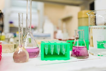 chemicals in beakers, laboratory glassware, colorful liquids, science lab, beakers, test tubes, lab equipment, scientific experiment, chemical solutions, lab setting, laboratory tools