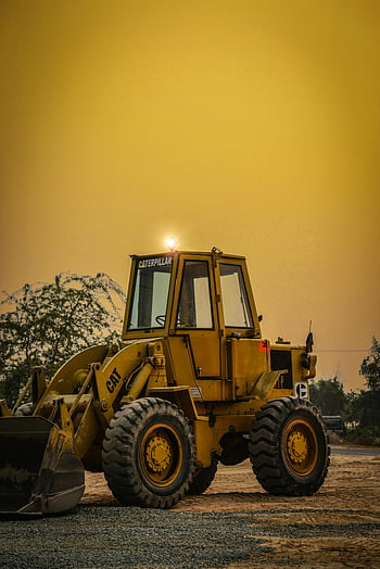 Yellow front loader, construction site, Layyah, Punjab, dusty evening, Caterpillar, heavy machinery, industrial equipment, outdoor work, yellow and black, large tires