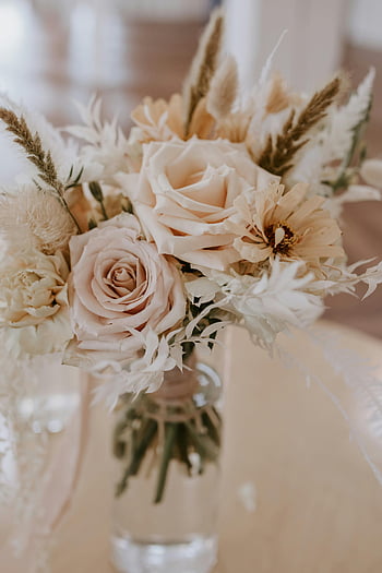 beige roses, dried flowers, glass vase, elegant decor, blooming flowers, water in vase, delicate arrangement, floral bouquet, soft colors, indoor flowers, table centerpiece