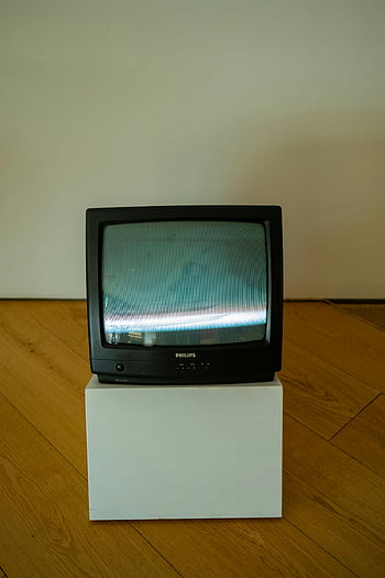 retro television, CRT television, minimalist room, white pedestal, classic TV, Philips TV, vintage TV, living room decor, minimalist decor, wooden floor, retro electronics