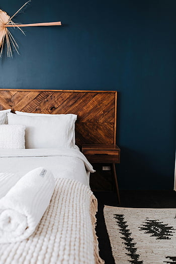 moderne slaapkamer, donkerblauwe muur, houten hoofdeinde, minimalistisch ontwerp, donker gekleurde muur, eigentijdse slaapkamer, Gezellige slaapkamer, stijlvolle slaapkamer, interieur ontwerp, slaapkamer inrichting, donkere muur slaapkamer