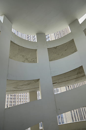 white concrete building, modern architecture, parking structure, architectural curves, light patterns, low angle view, urban design, contemporary building, concrete construction