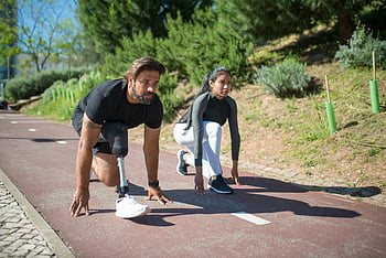 man and woman, getting ready to run, athletes, preparing to start, track, diversity, determination, prosthetic leg, outdoor running, fitness, sportsmanship
