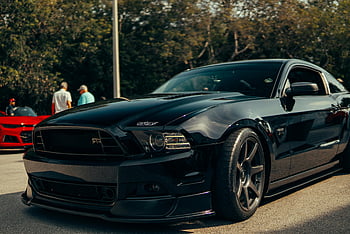Black Ford Mustang, sports car, outdoor auto show, parked car, black car, Ford Mustang, auto event, car show, Mustang sports car, outdoor event, car enthusiasts