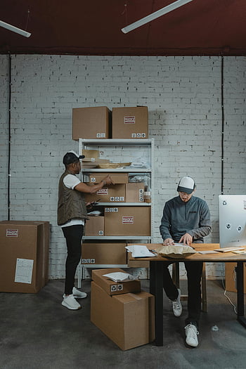 warehouse workers, organizing boxes, packing boxes, warehouse setting, male workers, cardboard boxes, work environment, warehouse organization, packing process, warehouse activity, warehouse tasks