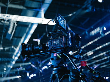 プロ用ビデオカメラ、 屋内イベント、 明るい会場、 クローズアップセットアップ、 ビデオ制作、 イベント写真、 カメラ機器、 三脚のセットアップ、 イベントカバレッジ、 プロのセットアップ、 屋内会場
