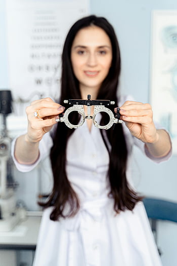 female optometrist, trial lens frame, eye examination, optometry, vision care, eye care professional, medical professional, eye chart, optical equipment, healthcare, vision testing