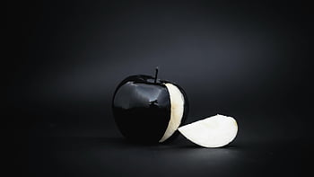 black apple, slice cut out, glossy black apple, dark background, artistic image, black apple slice, black fruit, dark fruit, black apple photography, black apple art, black apple still life