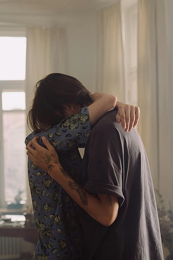 two people hugging, intimate hug, warmly lit room, love and tenderness, couple hugging, indoor hug, emotional moment, romantic embrace, tender moment, affectionate couple, heartfelt hug