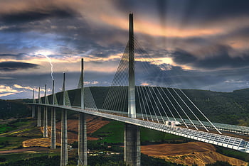 Millau Viaduct, sunset, dramatic sky, lightning, Occitanie, France, cable stayed bridge, modern architecture, scenic, infrastructure, travel photos