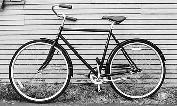 black and gray road bike, classic black bicycle, rustic wooden wall, outdoor setting, vintage bike, black bicycle, wooden background, outdoor bicycle, classic road bike, rustic setting, black and white photo
